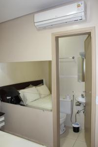 sypialnia z łóżkiem, toaletą i lustrem w obiekcie Hotel Albatroz w mieście Uberaba