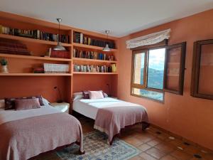 a bedroom with two beds and a window and shelves at Casa Rural El Mirador de la Vega in Horche +28 photos