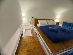 a bedroom with a bed with blue sheets and pillows at Flaviogioia Apartment in Naples