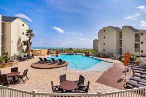a patio with a pool and tables and chairs at Bahia Mar-Solare Tower, Beachfront Resort with Two Pools in South Padre Island