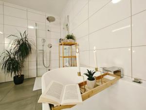 un bagno con una vasca bianca e un tavolo con un libro di Kaiserin Sisi für bis zu 6 - Arbeitsplatz, Badewanne, Parkplatz, Waschmaschine a Dinkelsbühl