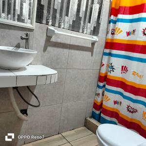 a bathroom with a sink and a shower curtain at Casita de camucha in Chincha Baja +5 photos