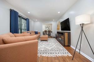 a living room with a couch and a television at Near Botanical Garden with a Pool Charming on Charing in Columbus