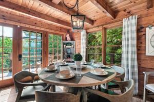 a dining room with a table and chairs and windows at Mountain views,King Beds, Pet Friendly, Private retreat in Pigeon Forge