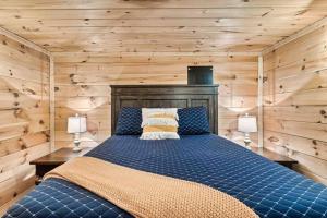 a bedroom with a blue bed with wooden walls at Mountain views,King Beds, Pet Friendly, Private retreat in Pigeon Forge