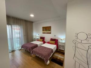 a hotel room with two beds and a window at Carreira Residence in Funchal