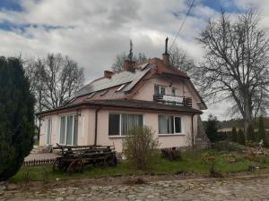 a large white house with a roof with solar panels at Pensjonat Lipowy Dworek in Staroguby