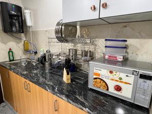 a kitchen counter with a microwave on top of it at Couple Love Condos 1BHK in Zirakpur