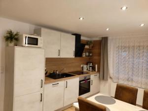 a kitchen with white cabinets and a sink and a microwave at Albi Haus Winterberg in Winterberg
