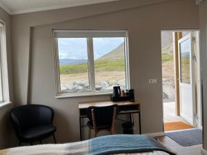 a bedroom with a desk and two chairs and a window at Strönd Guesthouse in Birkimelur  +24 photos