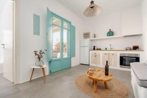 a living room with a blue door and a table at Ploes Seaside Houses in Plaka