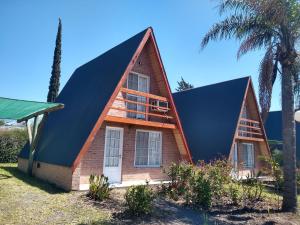 a small house with a gambrel roof at Cabañas LAS PALMERAS in La Paz