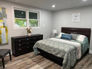 a bedroom with a bed and a dresser and window at Luxury and comfy Home- Niagara getaway in Niagara Falls