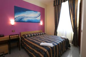 a bedroom with a bed and a desk and a painting at Hotel Loreto in Milan