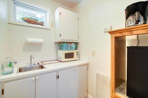 a kitchen with a sink and a microwave at Tennessee Farm Vacation Rental with Game Room! in Gadsden