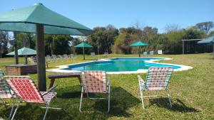 a group of chairs and an umbrella next to a pool at Cabañas LAS PALMERAS in La Paz