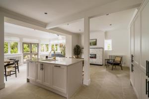 a kitchen with white cabinets and a dining room at Beaumont Exquisite Lakeland House, Sleeps 10 in Windermere