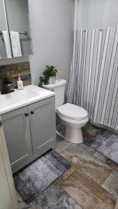 a bathroom with a toilet and a shower curtain at The Sunset Cottage - Wyoming by Primo Management in Rock Springs +34 photos