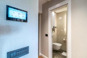 a bathroom with a flat screen tv on a wall at The Residence 59 in Belgrade +88 photos