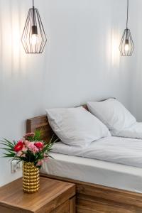 een slaapkamer met een bed met twee lampen en een tafel met bloemen bij Willa Nad Parkiem in Krynica Zdrój