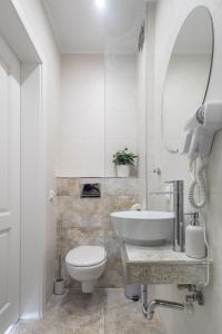 een badkamer met een wastafel, een toilet en een spiegel bij Willa Nad Parkiem in Krynica Zdrój