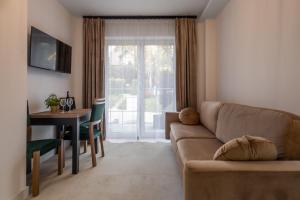 een woonkamer met een bank en een tafel bij Willa Nad Parkiem in Krynica Zdrój +23 foto's