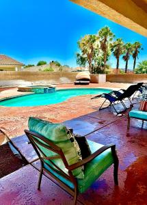 a pool with two lawn chairs and an umbrella at Casa Linda in Desert Hot Springs