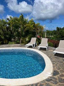a swimming pool with two lounge chairs and a swimming pool at Villa Karolina in Las Galeras