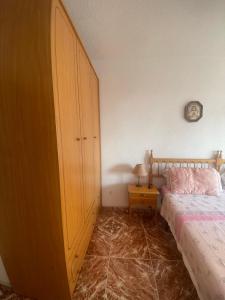 een slaapkamer met een bed en een houten kast bij Benidorm Levante in Benidorm