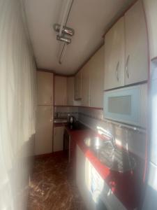 een keuken met een spoelbak en een magnetron bij Benidorm Levante in Benidorm