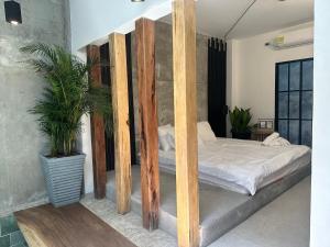 a bedroom with a bed with wooden posts and plants at Apartamento Céntrico con Jacuzzi in Mompos