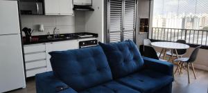 a living room with a blue couch in a kitchen at Apto Resort Brás Piscina, Ar-condicionado in São Paulo