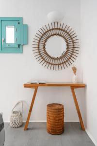 a mirror on a wall next to a wooden table at Ploes Seaside Houses in Plaka
