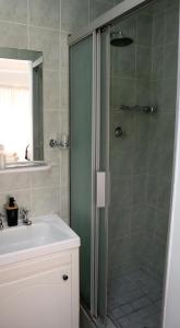 a bathroom with a shower and a sink at Strand Beach Townhouse Self Catering in Cape Town