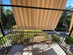 two chairs on a balcony with a large shade at Stylish King Downtown in Podgorica