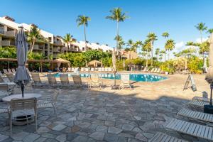 a resort swimming pool with chairs and an umbrella at Gorgeous Luxury Ocean View 1 Bedroom Kamaole Sands 10-304 in Wailea