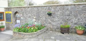 a stone wall with pots of flowers and plants at The Old Rectory - Brean in Brean
