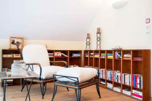 two chairs and a table in a room with bookshelves at Winzerzimmer Scharl in Sankt Anna am Aigen
