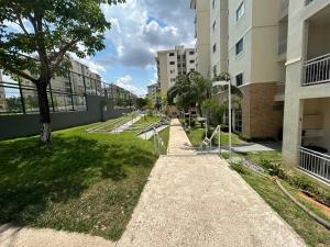 ein Gehweg mitten in einem Park mit Gebäuden in der Unterkunft Smile Parque das Flores in Manaus