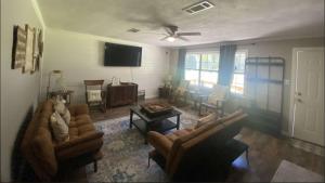 a living room with two couches and a table at Texas Tranquility Your Ideal Orange Rental Homes in Orange