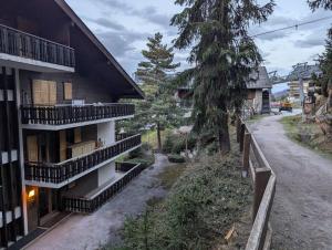 an apartment building with balconies and a dirt road at Studio Le Chamois - Veysonnaz in Veysonnaz