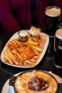 a plate of food with fish and french fries on a table at The Lenox Hotel Boston in Boston