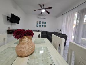 einen Esstisch mit einer Vase mit Blumen darauf in der Unterkunft Villa los Pepe's in Puerto Morelos