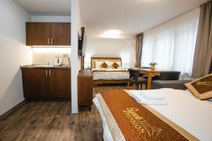 a hotel room with two beds and a kitchen at SYNEK Pension in Špindlerův Mlýn
