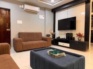 a living room with a couch and a tv at PRIVATE Luxury Homestay in Khammam in Khammam