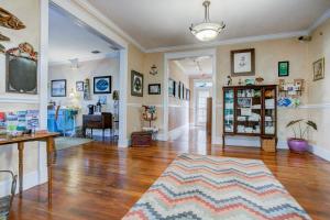 sala de estar amplia con suelo de madera y mesa en Anchor Inn NSB Bed and Breakfast en New Smyrna Beach