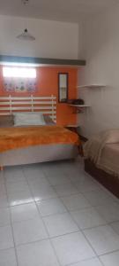 Un dormitorio con dos camas y una pared naranja. en Analina, en San Marcos Sierras