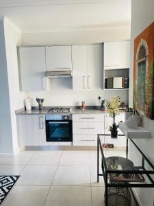 a kitchen with white cabinets and a blue oven at Peaceful Nest in Midrand