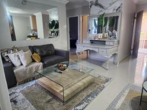 a living room with a couch and a glass coffee table at Lemon tree in Pretoria
