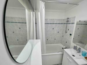 Un baño con bañera, lavabo y espejo. en T2 vue mer Palm Beach, en Le Barcarès 21 fotos más